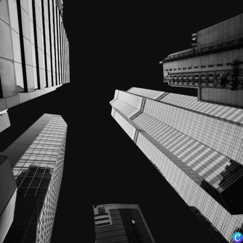 Vue en contre plongée d'immeubles sombres qui se découpent sur un ciel entièrement noir