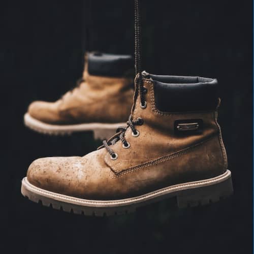 Photo d'une paire debottes qui pendouillent sur un fond noir
