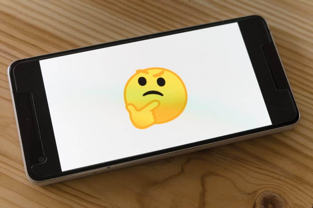 Photo d'un téléphone avec l'émoji smiley en pleine réflexion