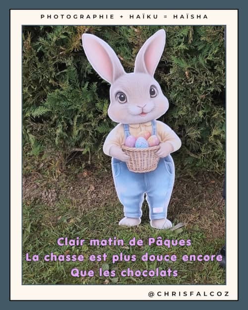 Photo d'une figurine en carton de lapin de Pâques avec son panier, devant un buisson